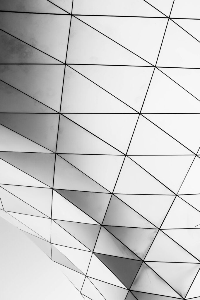 Black and white abstract image of a geometric architectural structure with triangles and patterns.